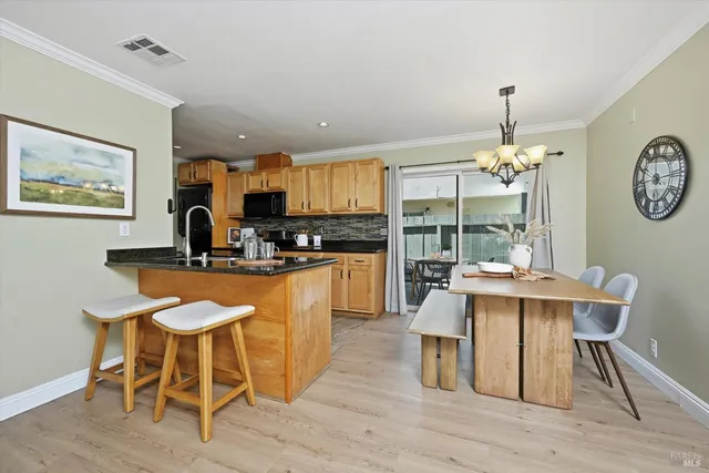 a kitchen with a dining table chairs and chandelier
