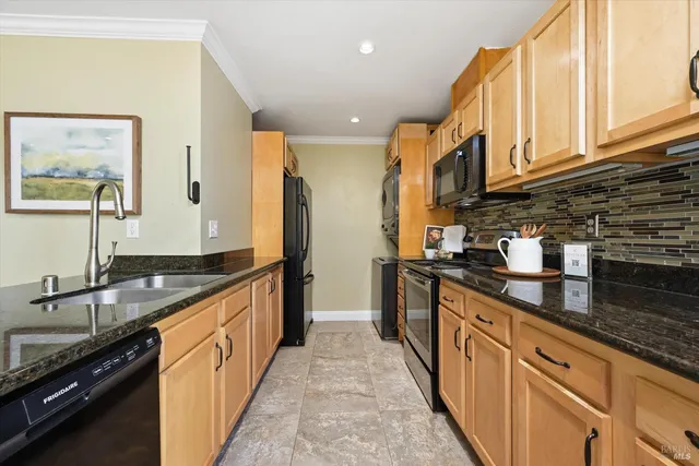 a kitchen with stainless steel appliances granite countertop a sink and a stove