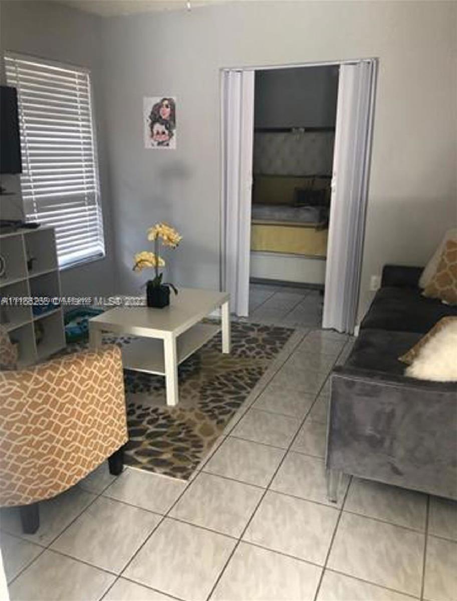 a hallway with a rug table and chairs
