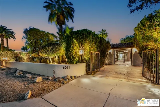 front view of house with a yard and palm trees