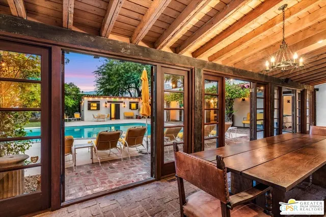 a dining room with furniture water view and a floor to ceiling window