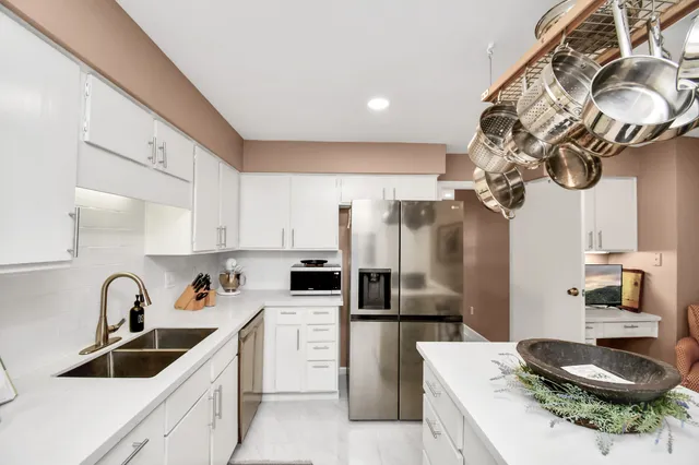 a kitchen with stainless steel appliances granite countertop a sink a stove a refrigerator and cabinets