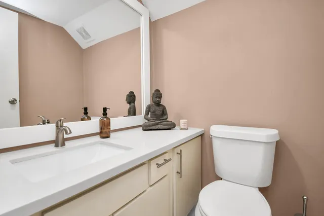 a bathroom with a toilet a sink and mirror