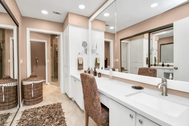 a large bathroom with double vanity sinks a large mirror and a shower