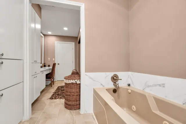 a bathroom with a tub sink and mirror