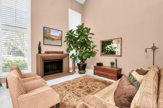a living room with furniture a chandelier and a fireplace