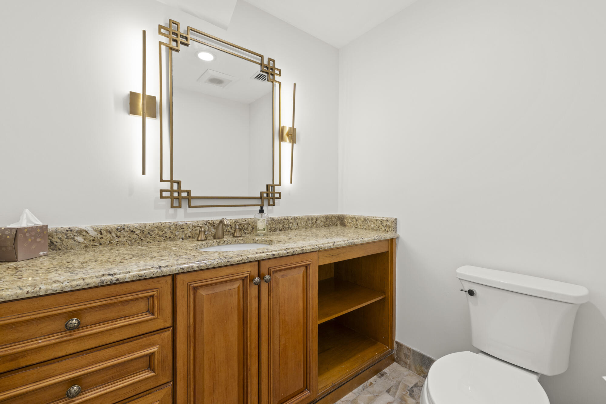 325 Eagle Drive Jupiter, FL 33477 - Photo 29 of 51 a bathroom with a granite countertop toilet sink and mirror