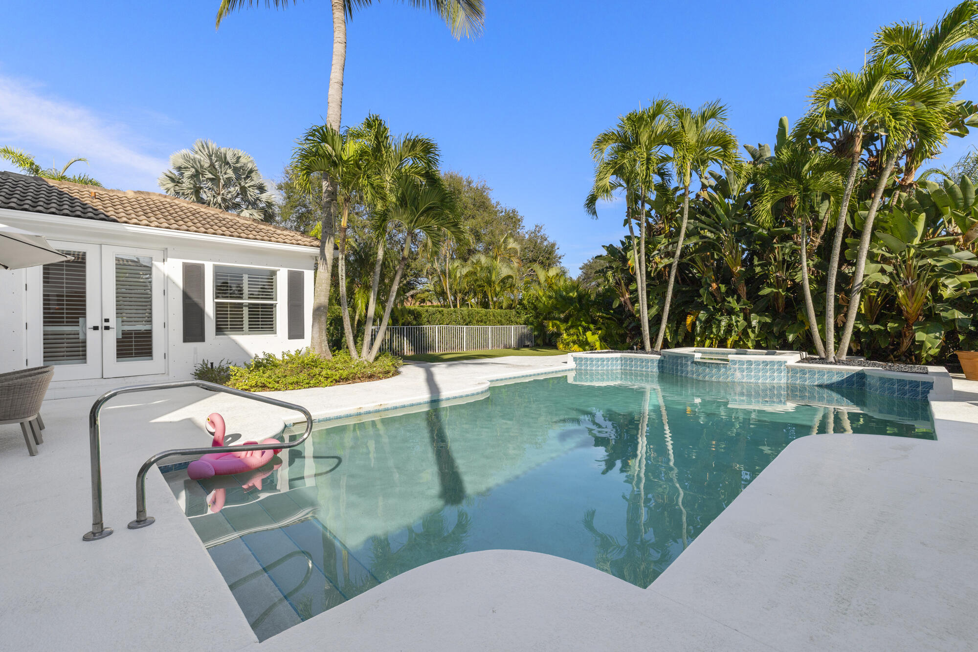 325 Eagle Drive Jupiter, FL 33477 - Photo 36 of 51 a view of a swimming pool with a lounge chairs