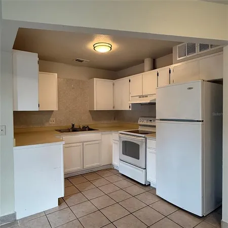 a kitchen with cabinets stainless steel appliances and sink