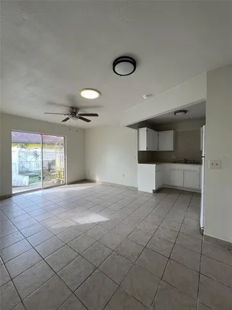 a view of empty room with windows and cabinet