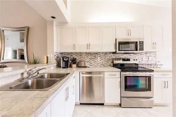 a kitchen with stainless steel appliances a stove a sink and a microwave