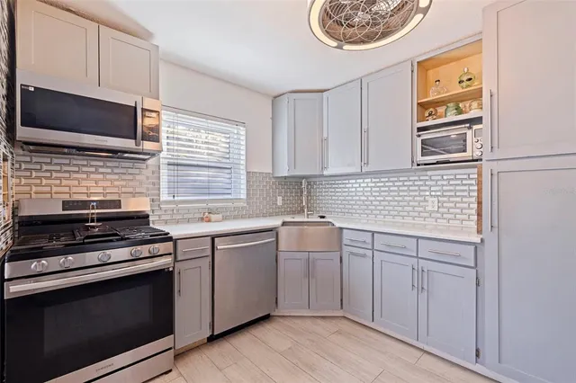 a kitchen with stainless steel appliances a stove sink and microwave