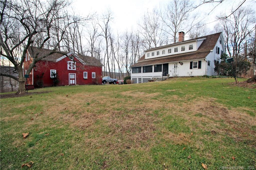 a view of a big house with a big yard and large trees