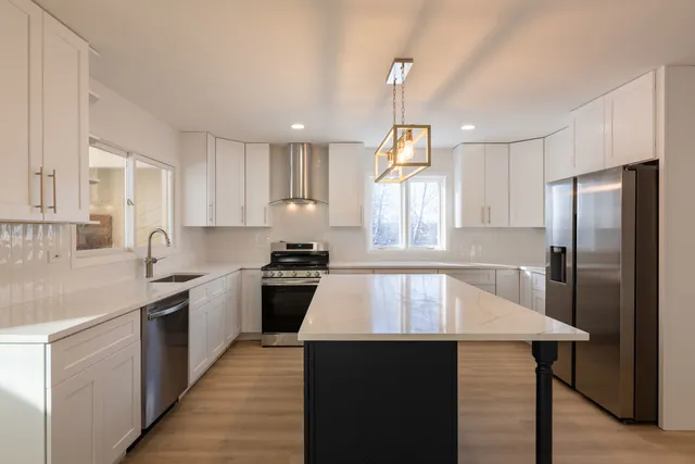 a kitchen with stainless steel appliances granite countertop a sink stove and wooden floor