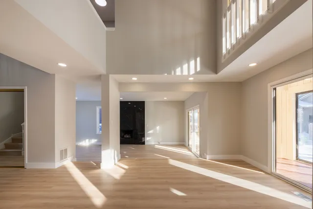 a view of a hallway view with wooden floor and a living room