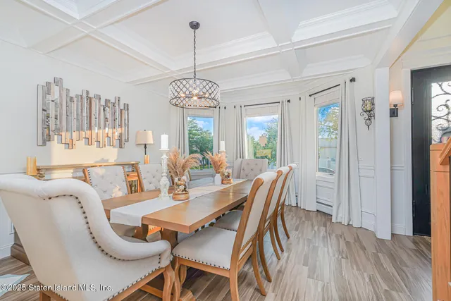 a dining room with stainless steel appliances kitchen island granite countertop a table chairs and a refrigerator