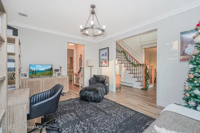 a kitchen with a sink stove and white cabinets with wooden floor