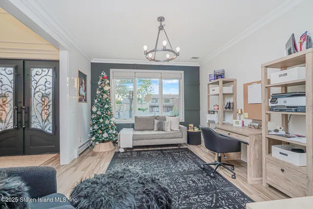 a view of a dining room and livingroom with furniture wooden floor a chandelier