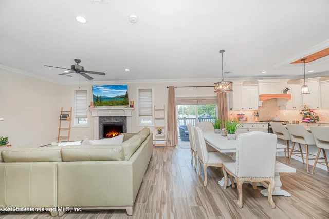 a living room with furniture kitchen view and a chandelier
