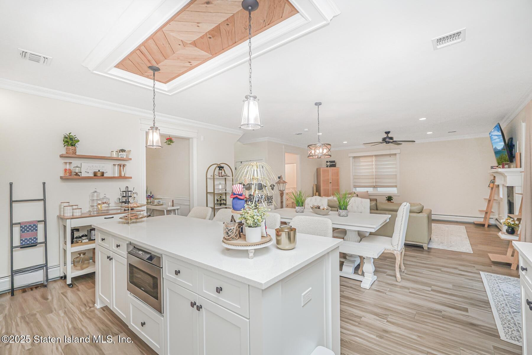 239 Vernon Avenue Staten Island, NY 10309 - Photo 23 of 67 a kitchen with a sink stove and white cabinets with wooden floor