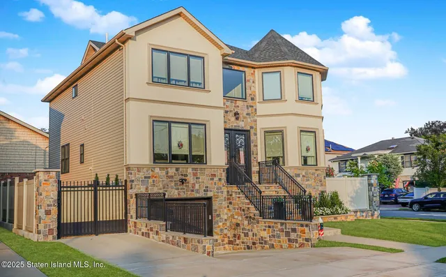 a view of a white house with a yard and plants