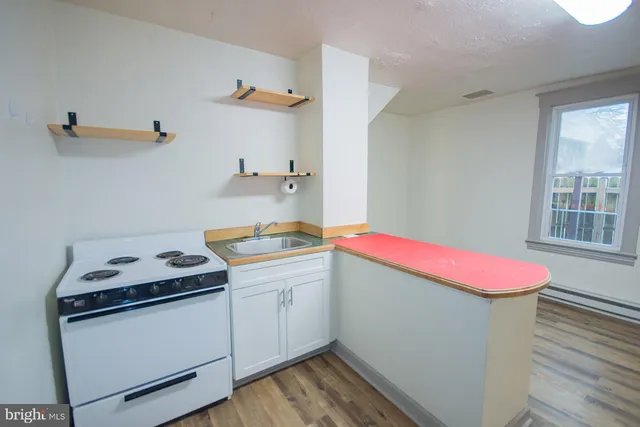 a kitchen with a sink cabinets and wooden floor
