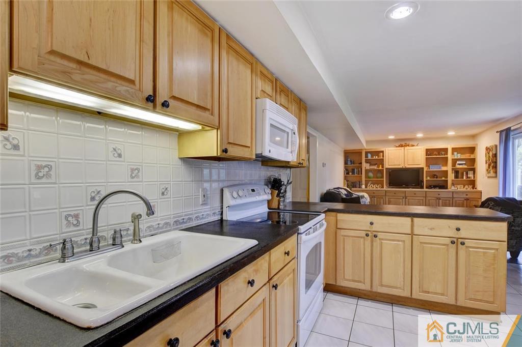 14 Drake Road Somerset, NJ 08873 - Photo 12 of 25 a kitchen with white cabinets a sink and dishwasher