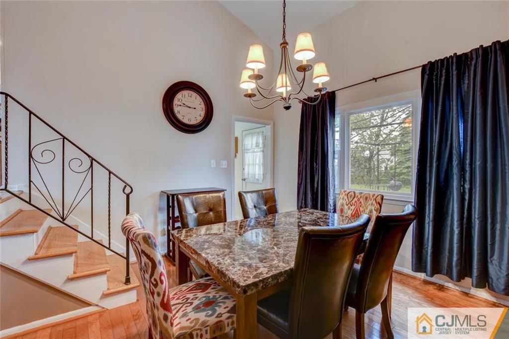 14 Drake Road Somerset, NJ 08873 - Photo 9 of 25 a dining room with wooden floor a chandelier a wooden table and chairs