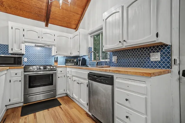 a kitchen with stainless steel appliances granite countertop a stove and a sink