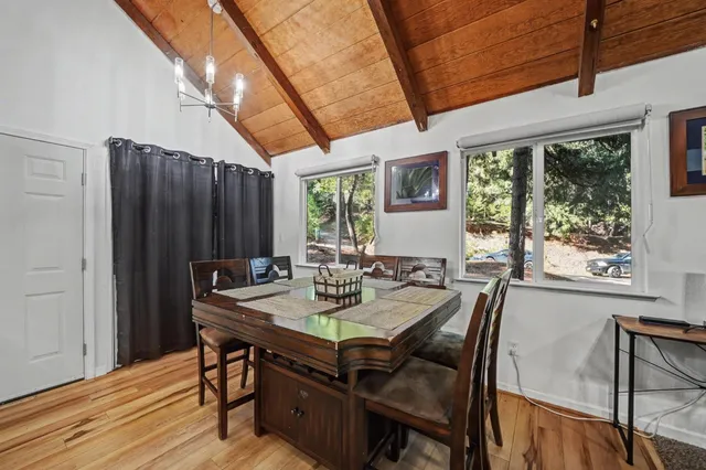 a open kitchen with stainless steel appliances kitchen island granite countertop a stove a sink a dining table and chairs with wooden floor