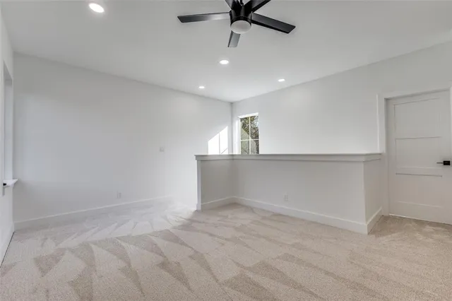 an empty room with a ceiling fan and window