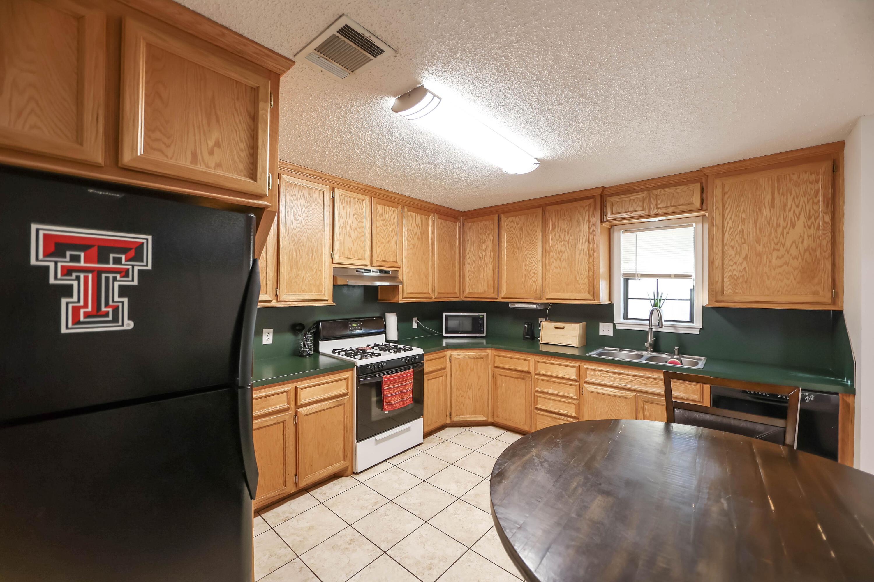 4607 33rd Street Lubbock, TX 79410 - Photo 6 of 22 a kitchen with stainless steel appliances granite countertop a stove a sink and a refrigerator