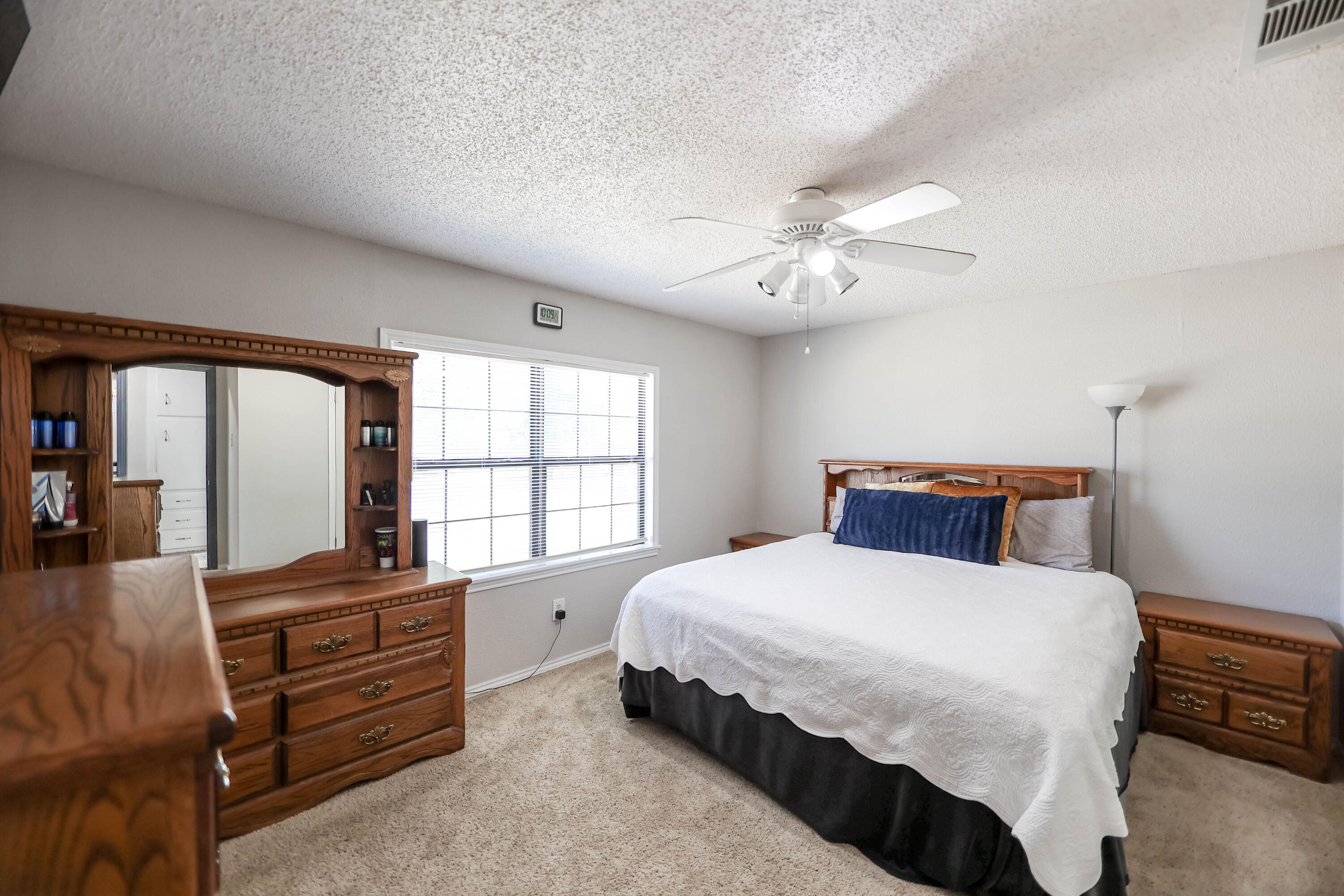 4607 33rd Street Lubbock, TX 79410 - Photo 8 of 22 a bedroom with a bed and a chandelier
