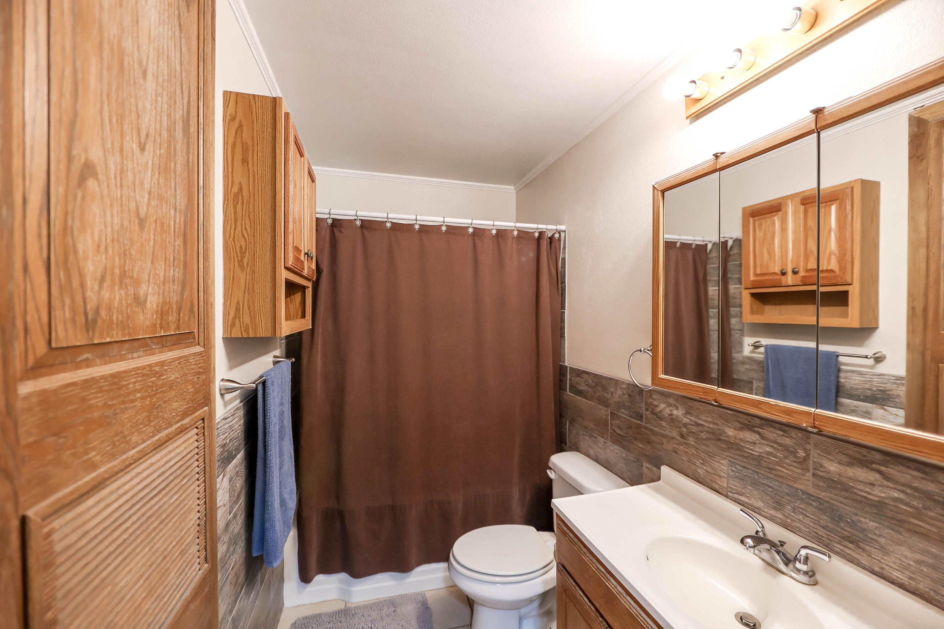 4607 33rd Street Lubbock, TX 79410 - Photo 10 of 22 a bathroom with a sink a toilet a mirror and shower