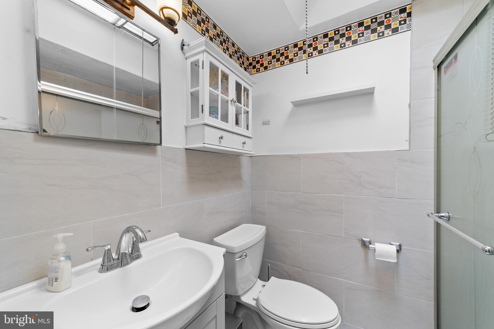 1314 Farrington Road Philadelphia, PA 19151 - Photo 11 of 21 a bathroom with a sink a toilet and mirror
