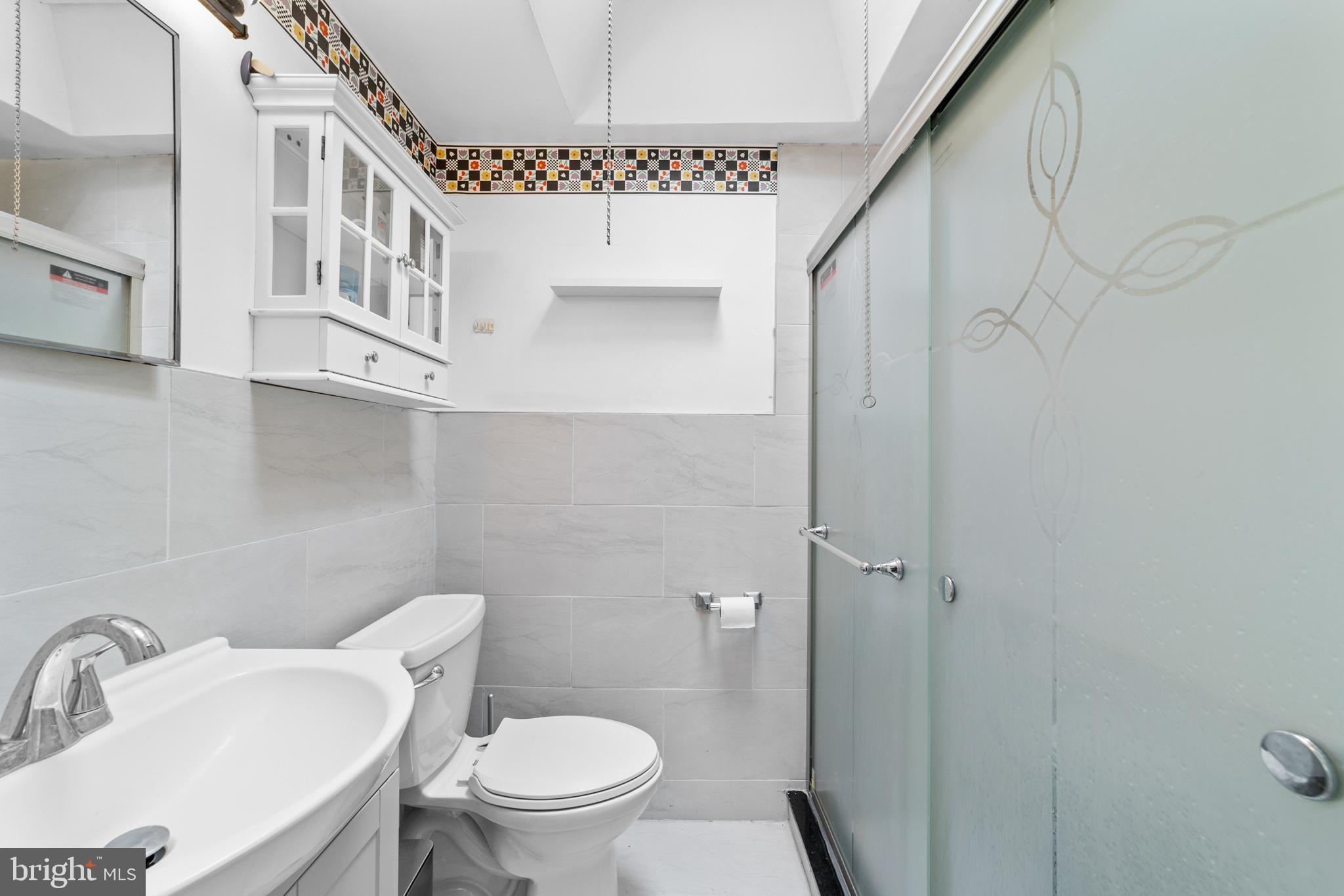 1314 Farrington Road Philadelphia, PA 19151 - Photo 10 of 21 a bathroom with a toilet a sink and mirror