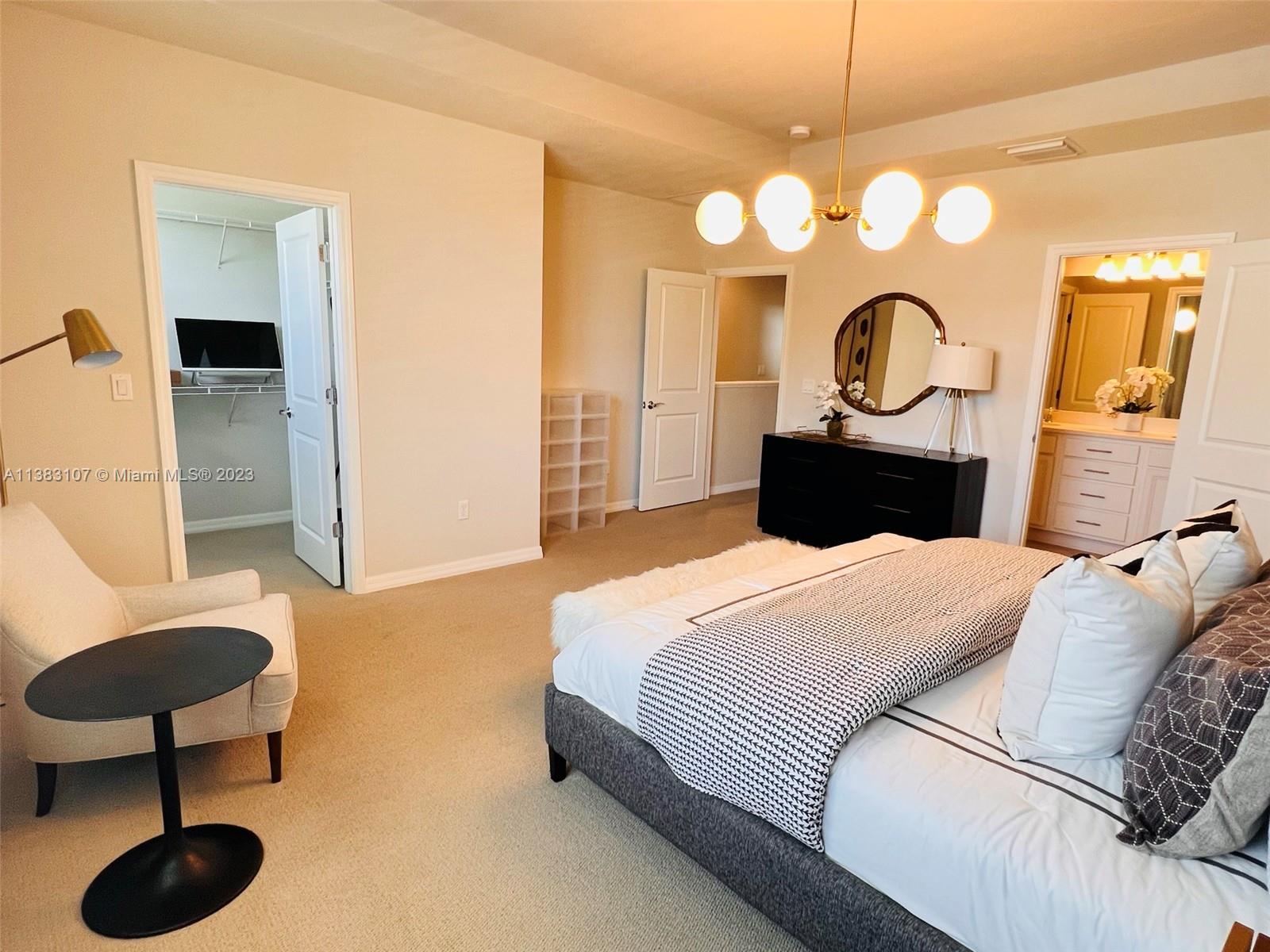 4002 Long Leaf Lane, Unit 6 Hollywood, FL 33021 - Photo 17 of 35 a bedroom with a bed and a chandelier