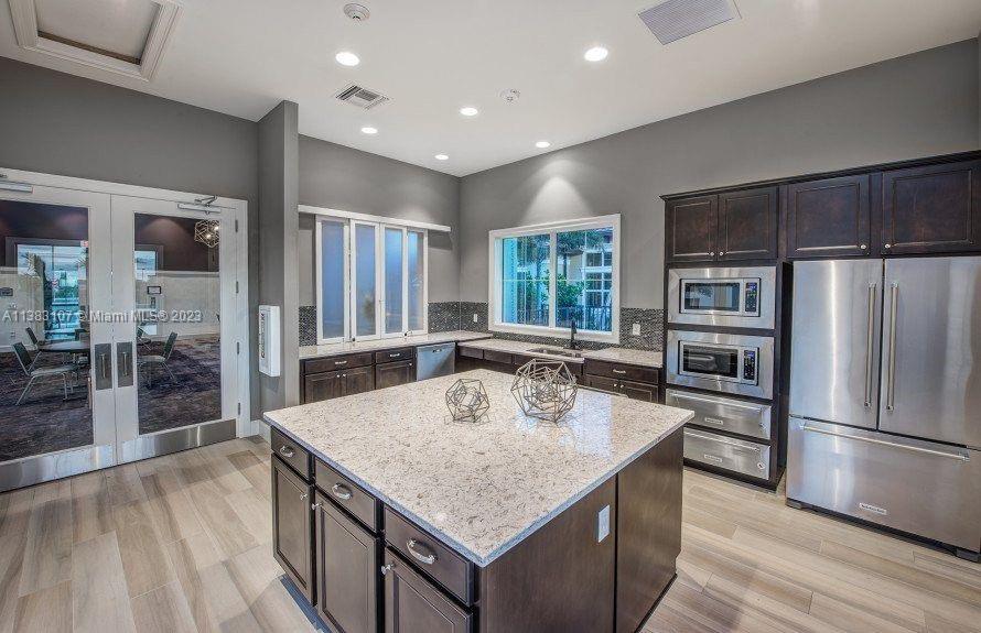 4002 Long Leaf Lane, Unit 6 Hollywood, FL 33021 - Photo 33 of 35 a kitchen with kitchen island a counter top space stainless steel appliances and a wooden floor