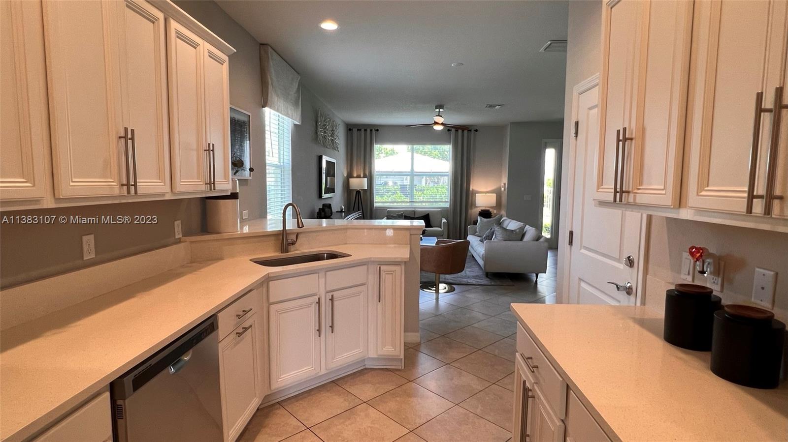 4002 Long Leaf Lane, Unit 6 Hollywood, FL 33021 - Photo 7 of 35 a kitchen with a sink dishwasher and white cabinets with wooden floor