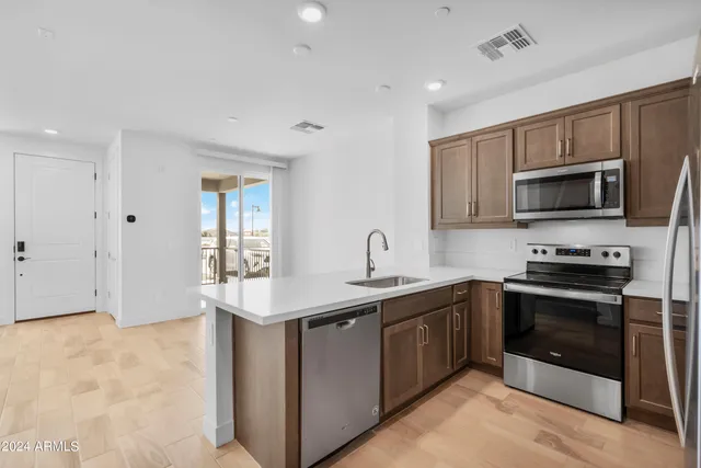 a kitchen with stainless steel appliances granite countertop a sink stove and microwave
