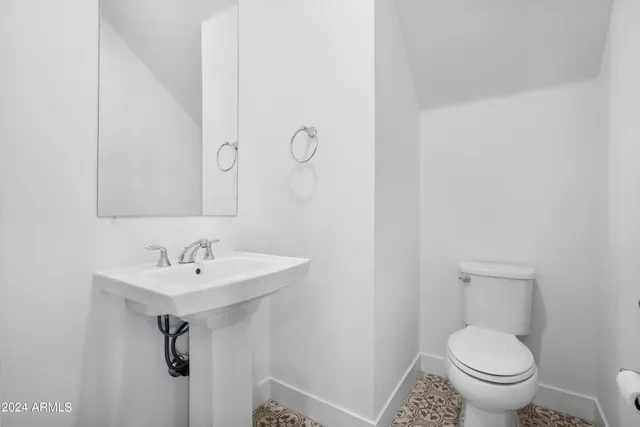 a bathroom with a sink toilet and a mirror