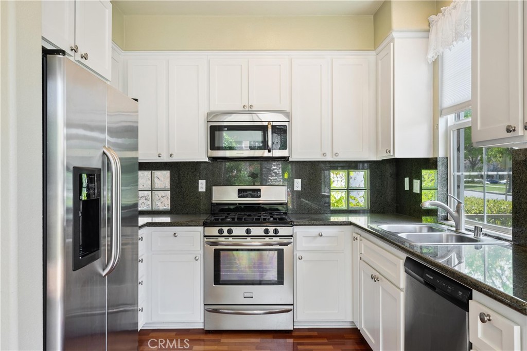 5 Second Street Ladera Ranch, CA 92694 - Photo 14 of 36 a kitchen with granite countertop a stove a sink and a microwave