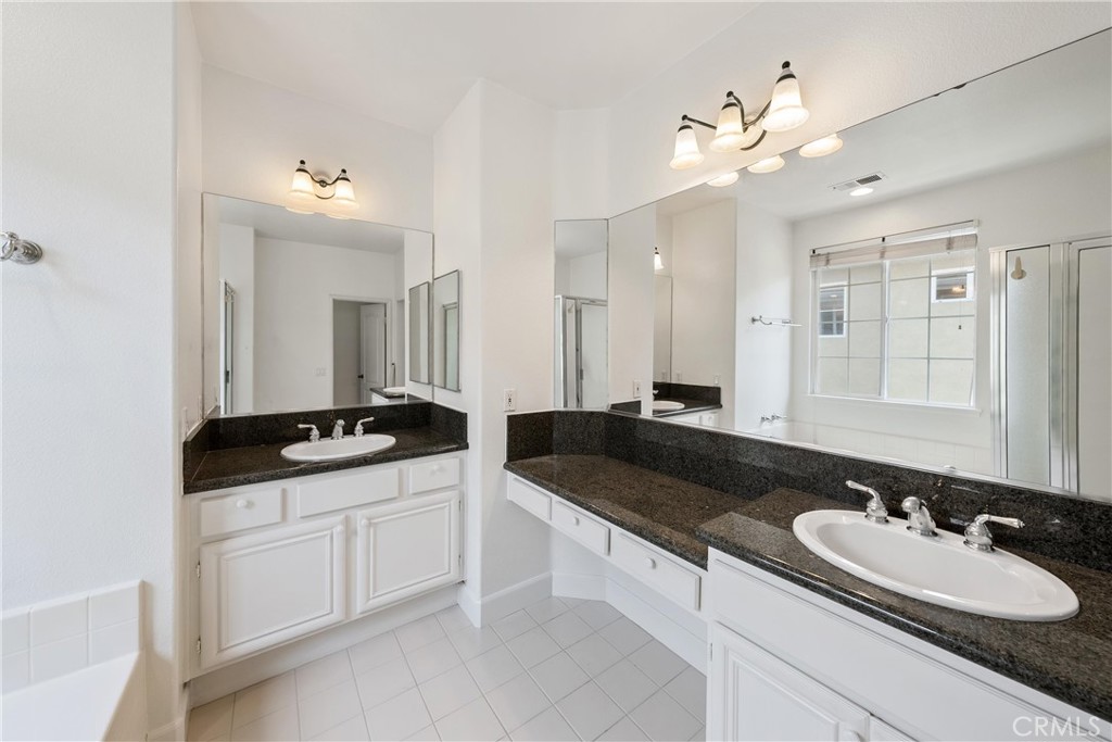 5 Second Street Ladera Ranch, CA 92694 - Photo 32 of 36 a bathroom with a granite countertop sink a large mirror and a