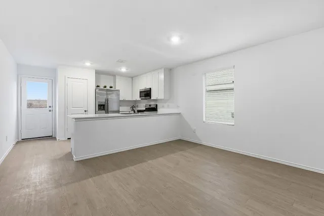 a view of kitchen with refrigerator and window