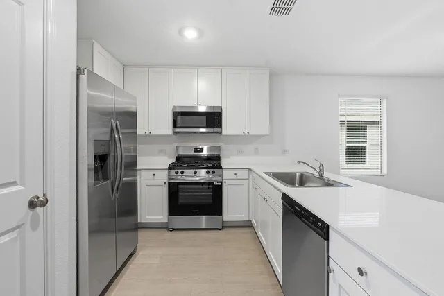 a kitchen with a sink stove and refrigerator