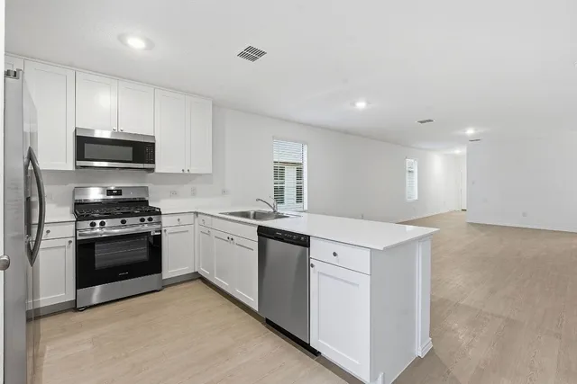 a kitchen with stainless steel appliances and white cabinets