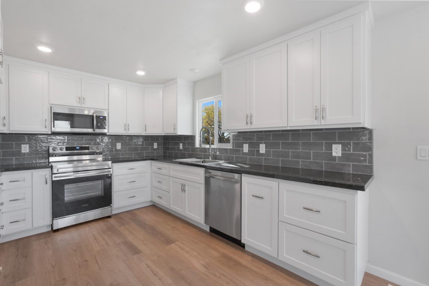 2324 Quail Hill Road Copperopolis, CA 95228 - Photo 11 of 37 a kitchen with granite countertop white cabinets and stainless steel appliances