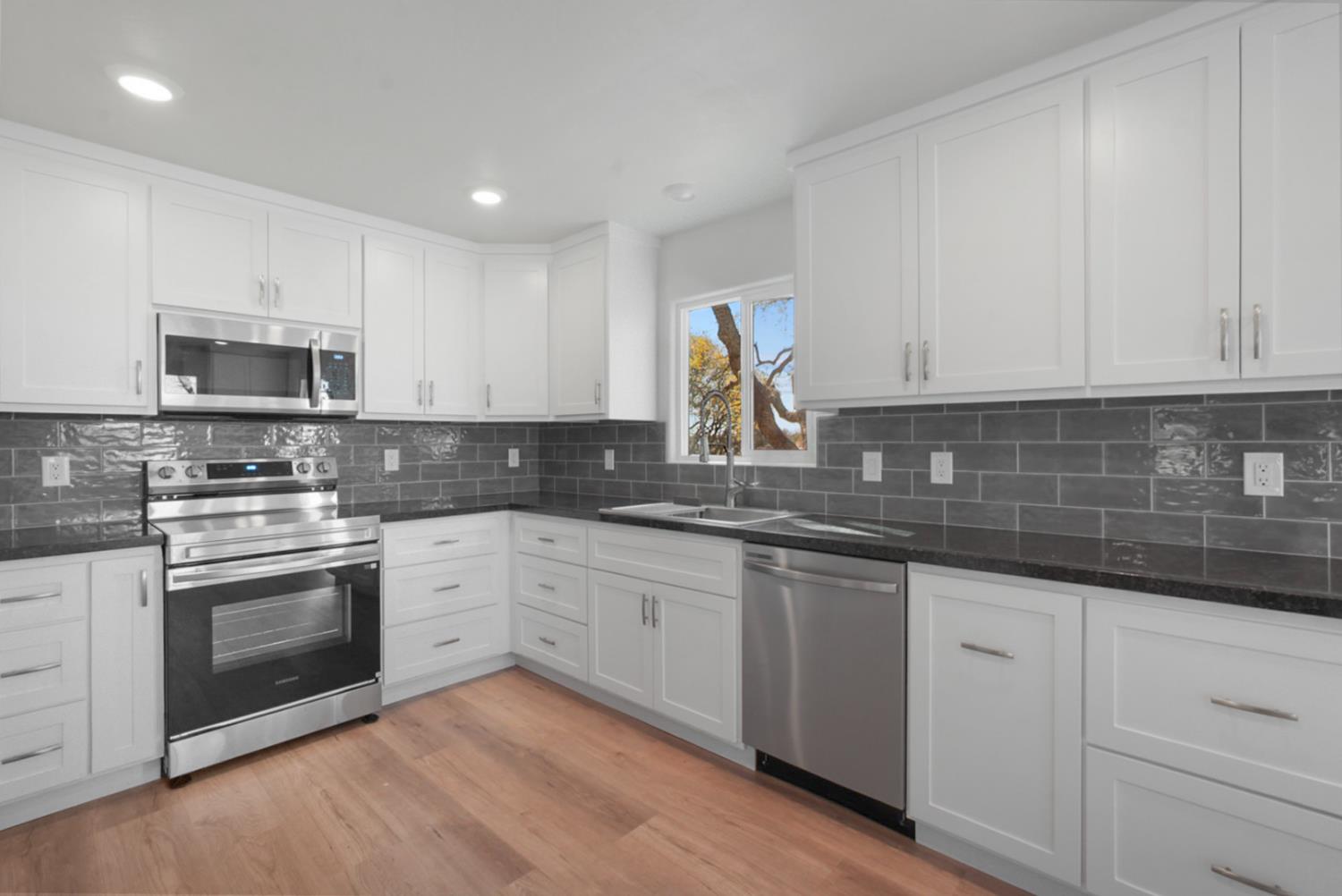2324 Quail Hill Road Copperopolis, CA 95228 - Photo 12 of 37 a kitchen with granite countertop white cabinets white stainless steel appliances with a sink and dishwasher