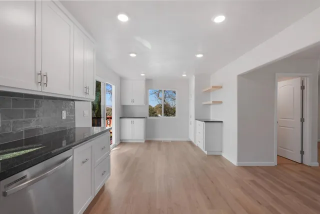 a large kitchen with cabinets and wooden floor