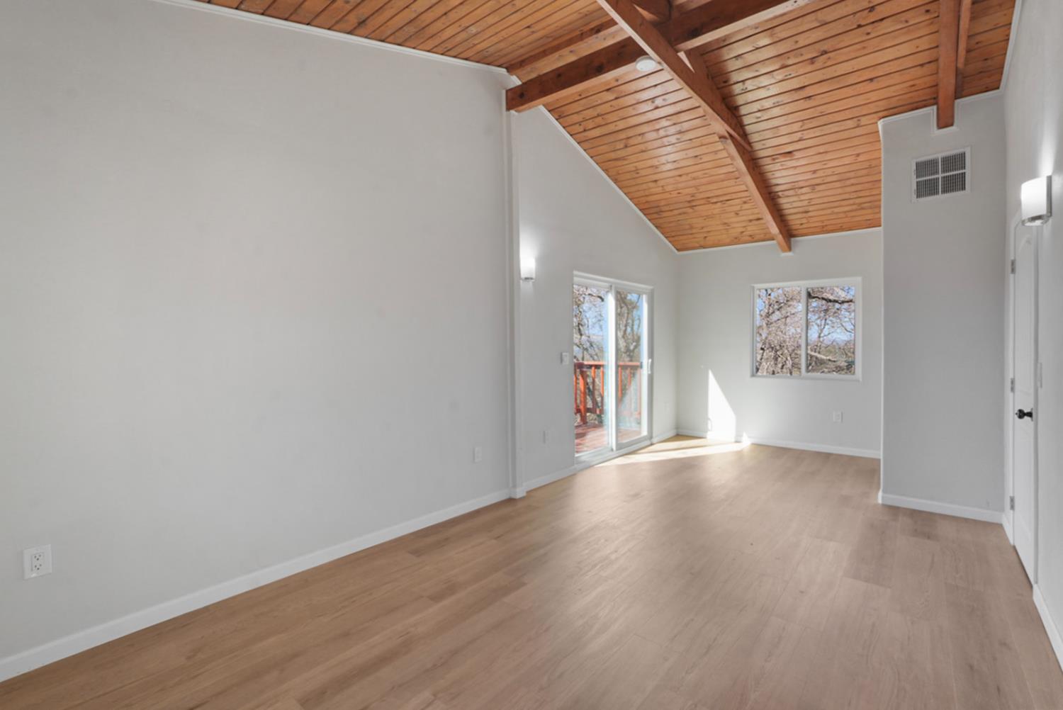 2324 Quail Hill Road Copperopolis, CA 95228 - Photo 17 of 37 an empty room with wooden floor and windows